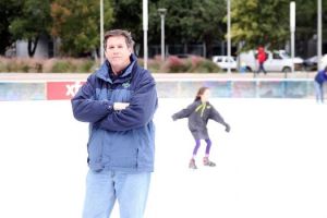 Mike Clayton stands on the ice at the Discovery Green rink in Houston, while skaters enjoy some exercise behind him. Clayton's company Ice Rinks Events, is based in The Woodlands.