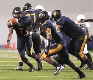 Nimitz quarterback Darrell Stewart (7) tosses the ball to running back Joseph Love (25) during the first half of a high school football game at W.W.Thorne Stadium Thursday.