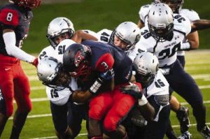 College Park defenders swarm Aldine Davis’ Lexington Thomas on Friday at W.W. Thorne Stadium in Houston.
