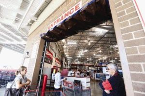 Customers and employees of Costco walk by a roll up door that was hit by a van during an attempted break-in on Tuesday morning. MCSO detectives are searching for those responsible for the more than $5,000 in damage to the building.