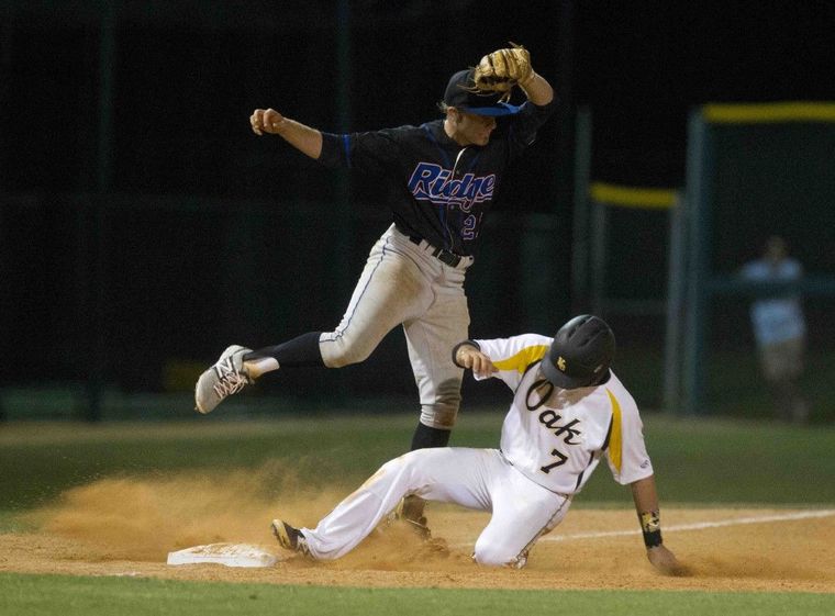 Oak Ridge third baseman Brock Woody tries to complete the tag of Klein Oak’s Colin Durrett during a bi-district playoff game.