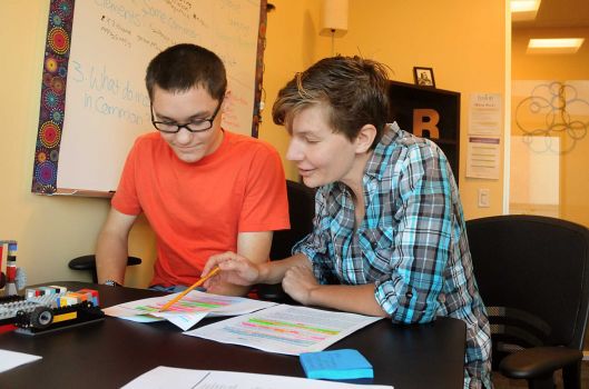 Fourteen-year-old Garrett Brotherhood and teacher Rachel Harper discuss one of Brotherhood's essays at the Fusion Academy inside The Woodlands Mall.