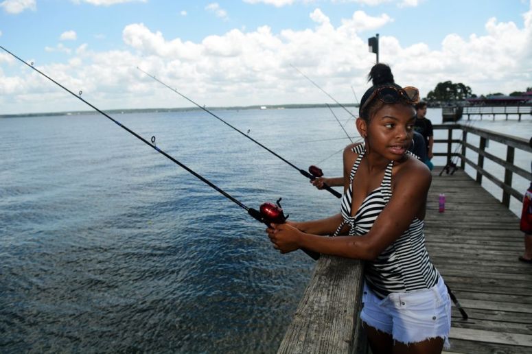Makayla Perryman, 16, an 11th grader at Oak Ridge High School, tries her luck at fishing during the Conroe ISD Police Activity League summer camp program picnic at Lake Conroe Park on Friday, July 17, 2015.