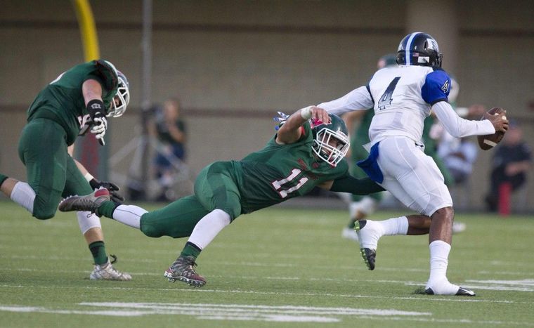 Dekaney quarterback Adrian Hardy is tackled by The Woodlands linebacker Zach La Canfora during a high school football game Thursday. 