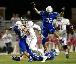The Woodlands quarterback Eric Schmid runs for a first down and more as Oak Ridge defensive end Lane Tuck leaps over linebacker Brennan Young during the first half of football game Friday. 