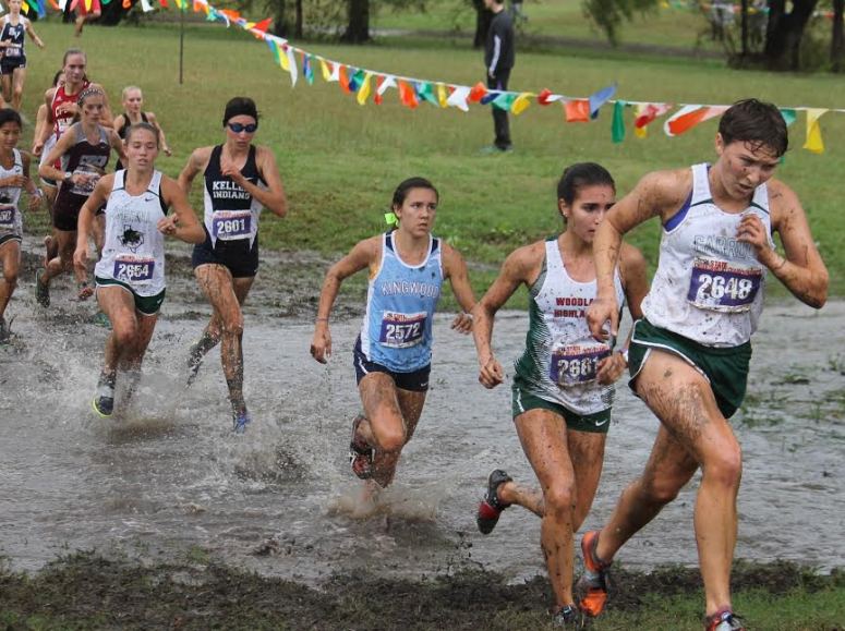 Kingwood Mustang Abby Guidry crosses a drainage gully at the UIL State Cross Country Championship on Saturday. Kingwood finished fourth in the 6A team competition.