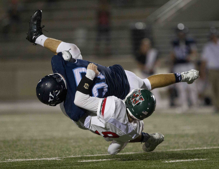 Kingwood's Benn Beckelman drives The Woodlands quarterback Harry Woodberry into the ground in the fourth quarter of a District 16-6A football game November 5, 2015, in Humble.