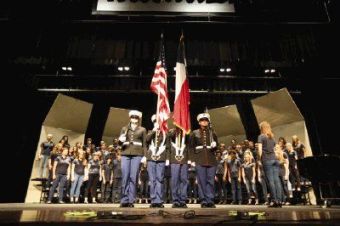 The Woodlands College Park High School JROTC color guard members present the U.S. and Texas flags as choir students perform the National Anthem during the Songs of Freedom choir tribute to veterans on Saturday at The Woodlands College Park High School