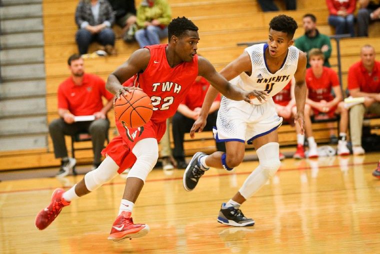 The Woodlands' Romello Wilbert (22) drives for the basket as Fort Bend Elkins' Chad Bowie (4) guards during the high school boys basketball game on Saturday at The Woodlands High School.
